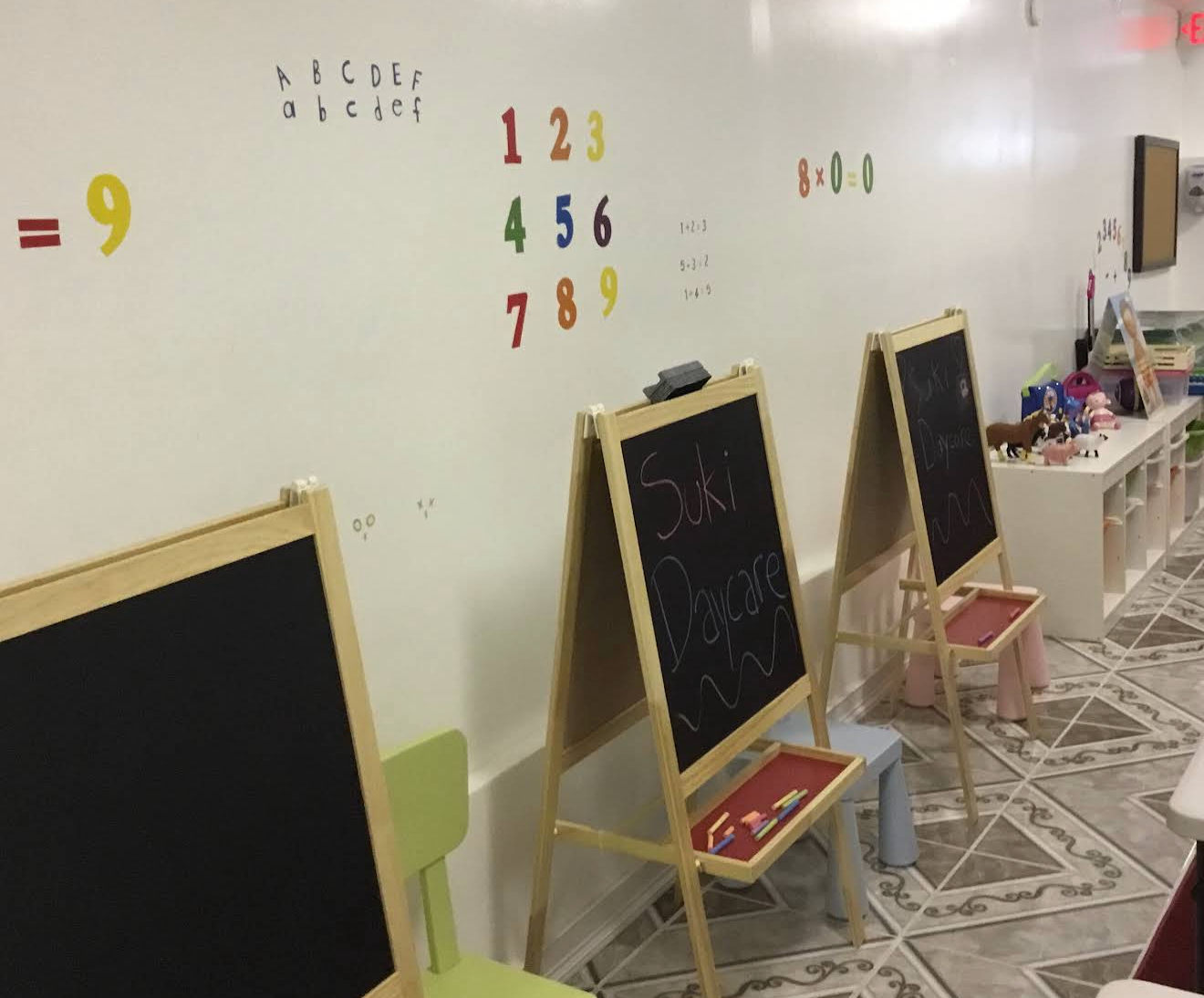 Suki Daycare classroom learning area with chalkboards and educational activities